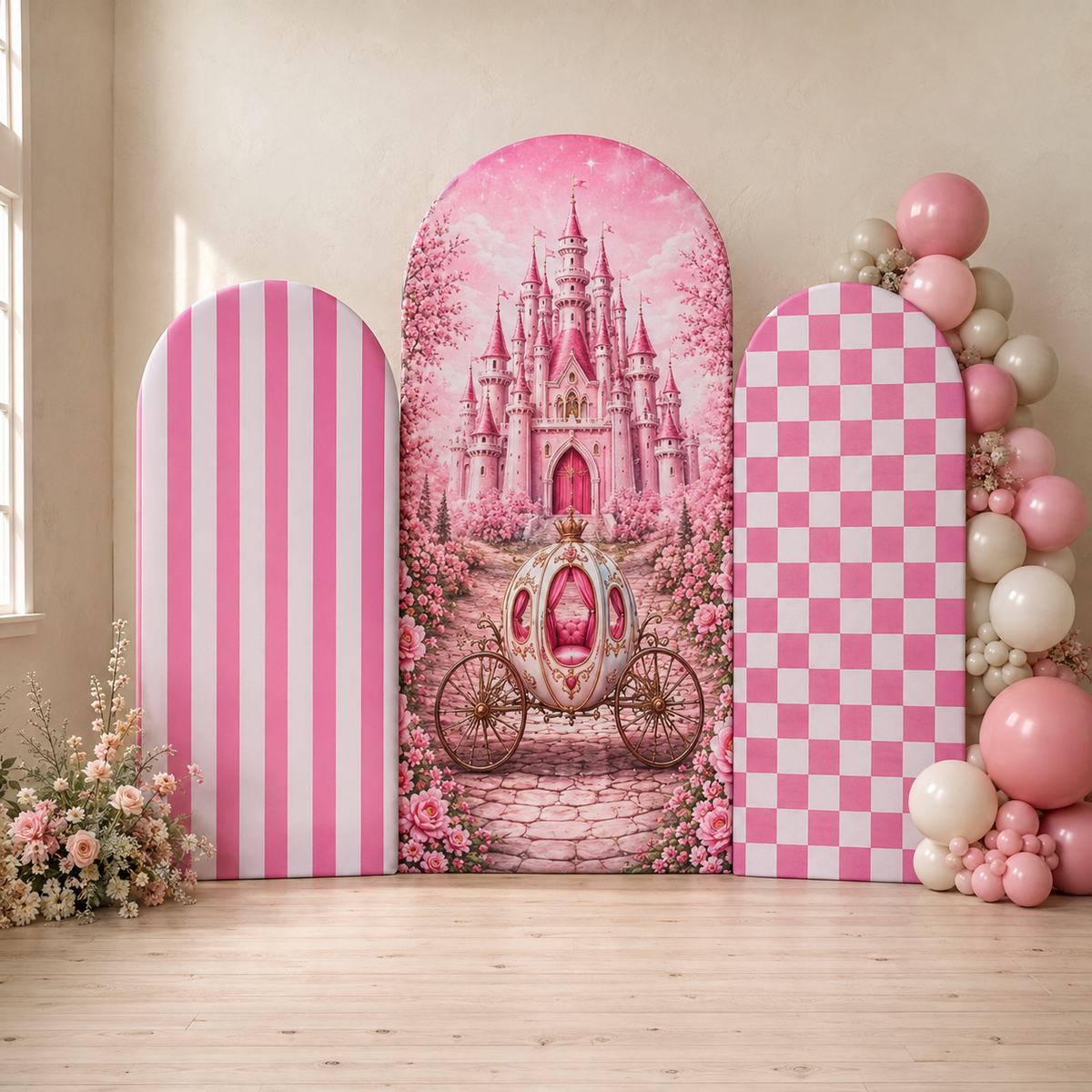 Pink princess-themed party backdrop set featuring a central arched panel with a pink castle and carriage, flanked by two matching arch panels with pink stripes and pink-and-white checkers, styled with balloon garlands and flowers on a light wood floor.